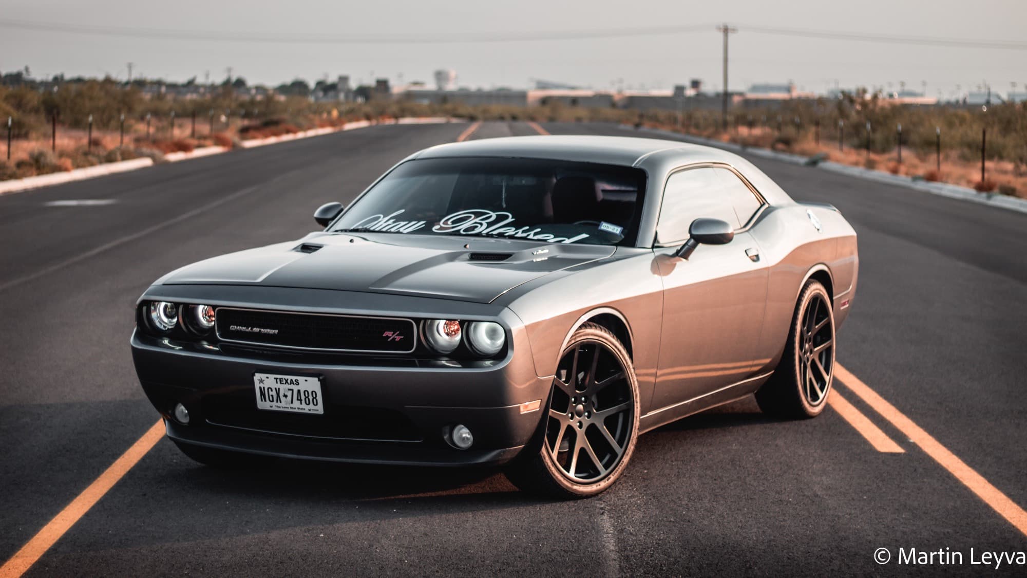 A grey 2012 Dodge Challenger R/T running the Factory Reproductions Fr64 22x10 +18 with Versatyre Trx6000 265/35 and Stock Suspension
