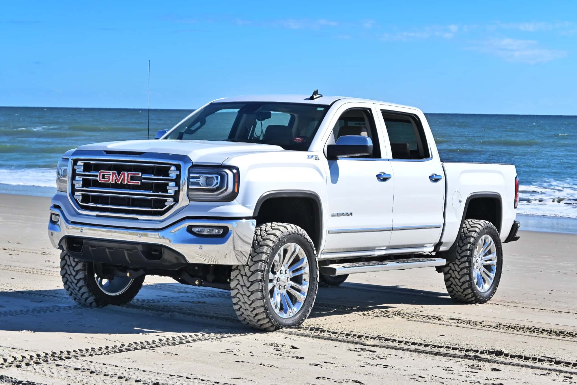 A silver 2018 GMC Sierra 1500 running the Factory Reproductions Fr55 22x9 +24 wrapped in Toyo Tires Open Country M/t 35