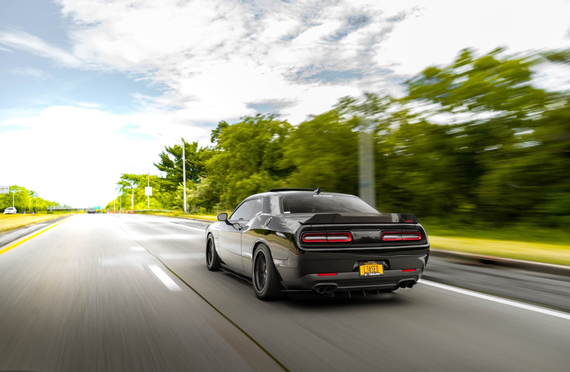 A roller of a black modified Dodge Challenger R/T running OE Replica wheels from Factory Reproductions